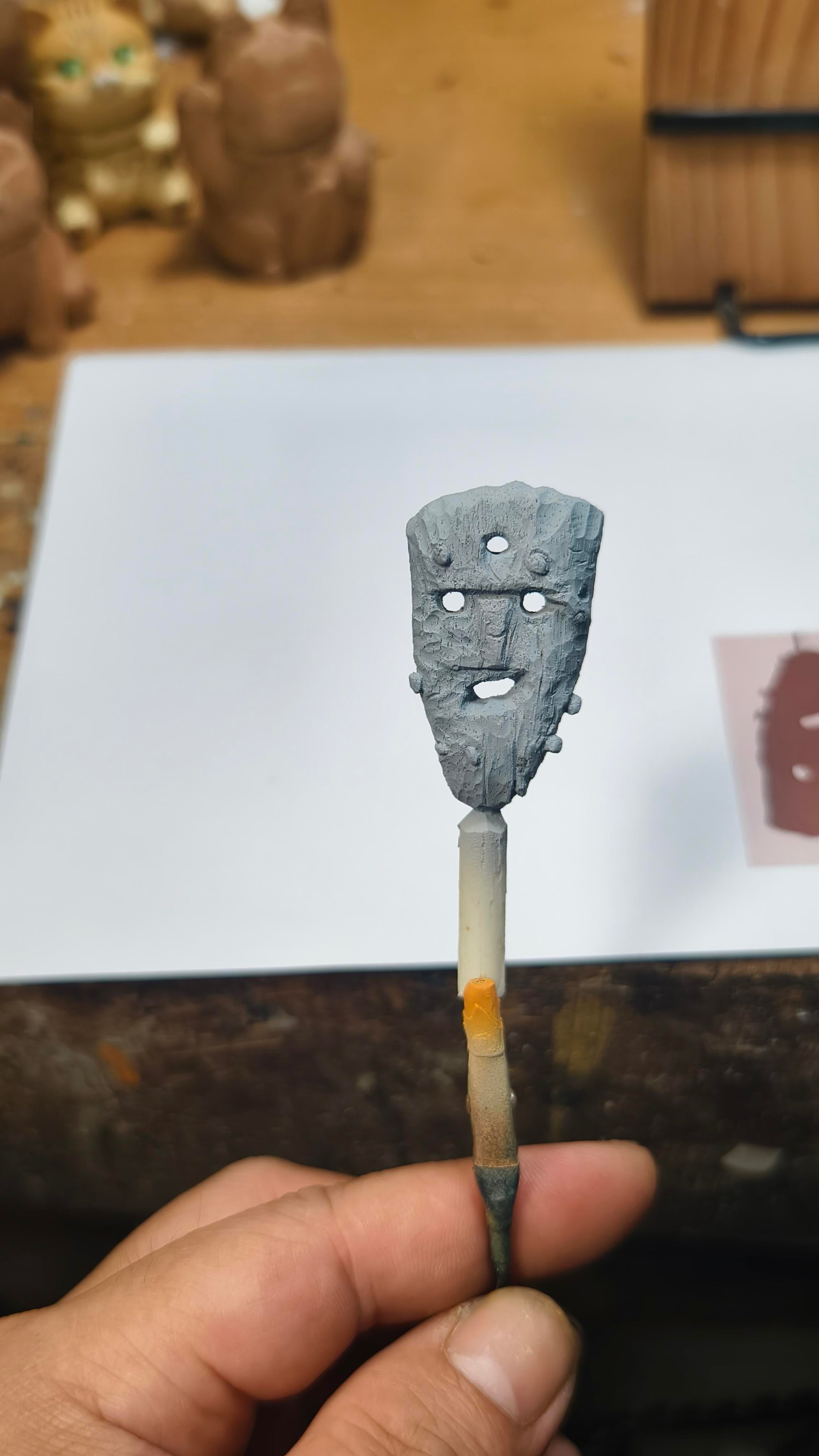 Small Icelandic mask held by a hand on a blurred background