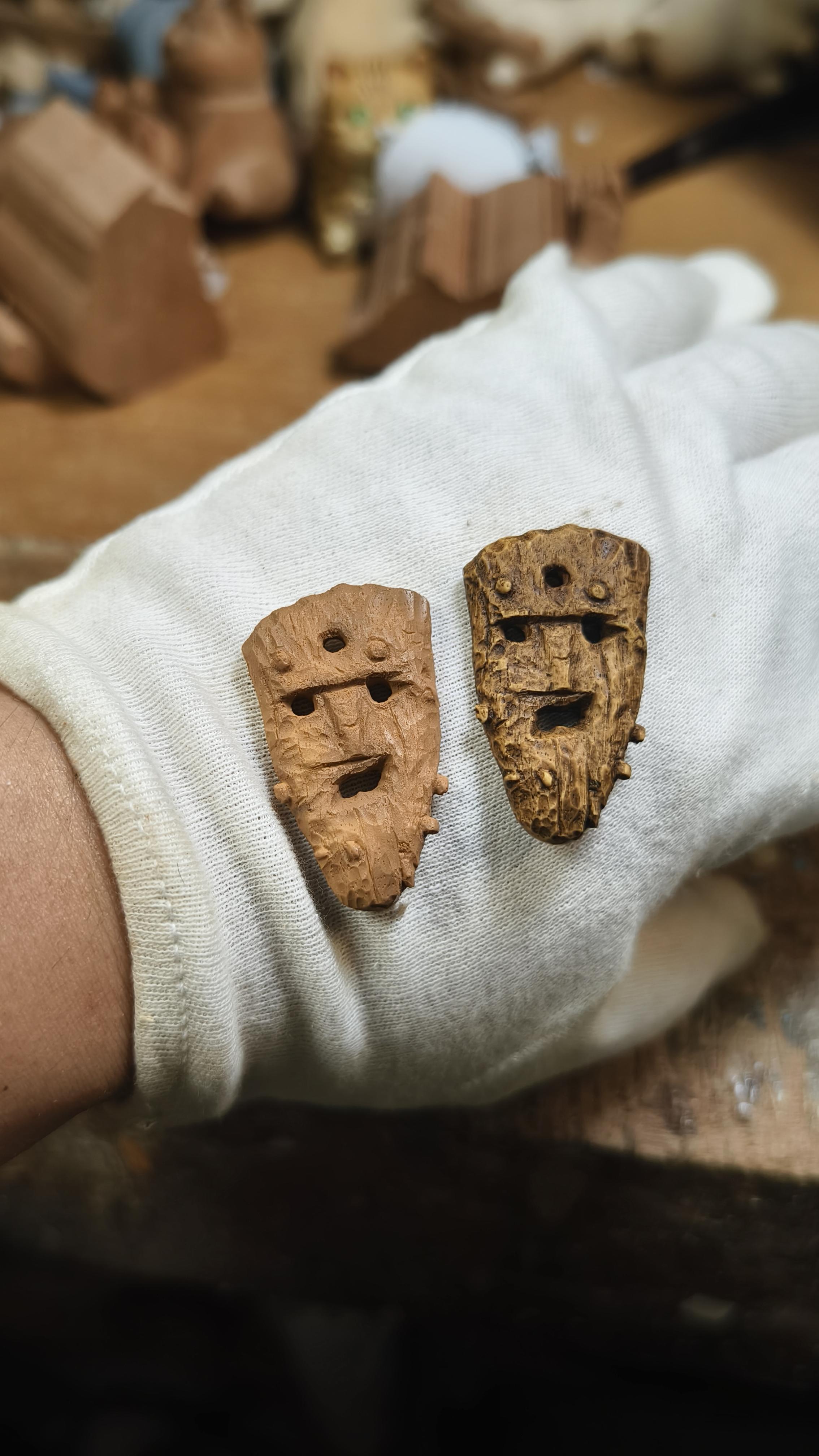 Two icelandic ancient artifacts held in a gloved hand with a blurred background